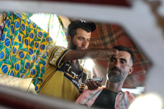بيدٍ واحدة.. جهاد المبحوح حلاق بغزة يقاوم البتر ويصنع الأمل في خيام النزوح